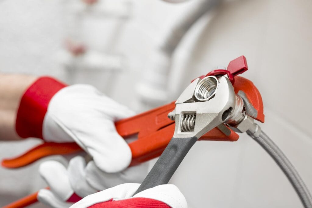 Plumber holding pipe wrenches for an emergency repair in Largo