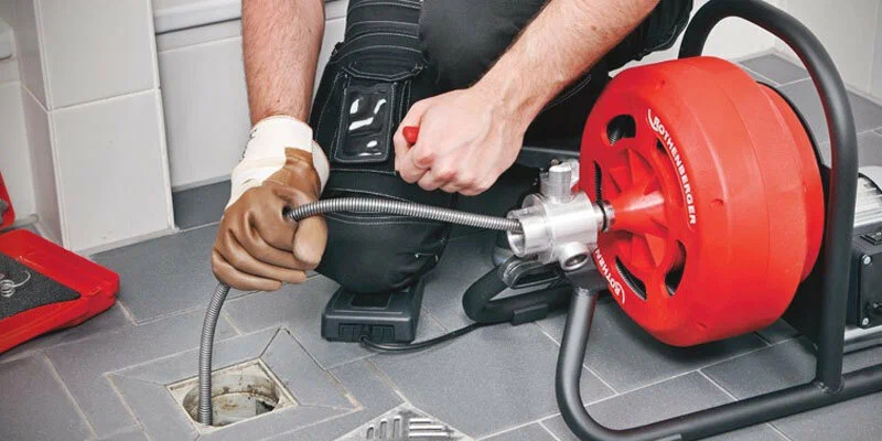 Plumber using a drain-cleaning machine in Largo
