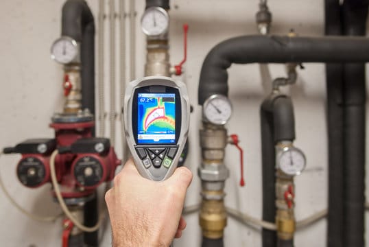 Plumber using a thermal imaging camera to inspect pipes in Largo