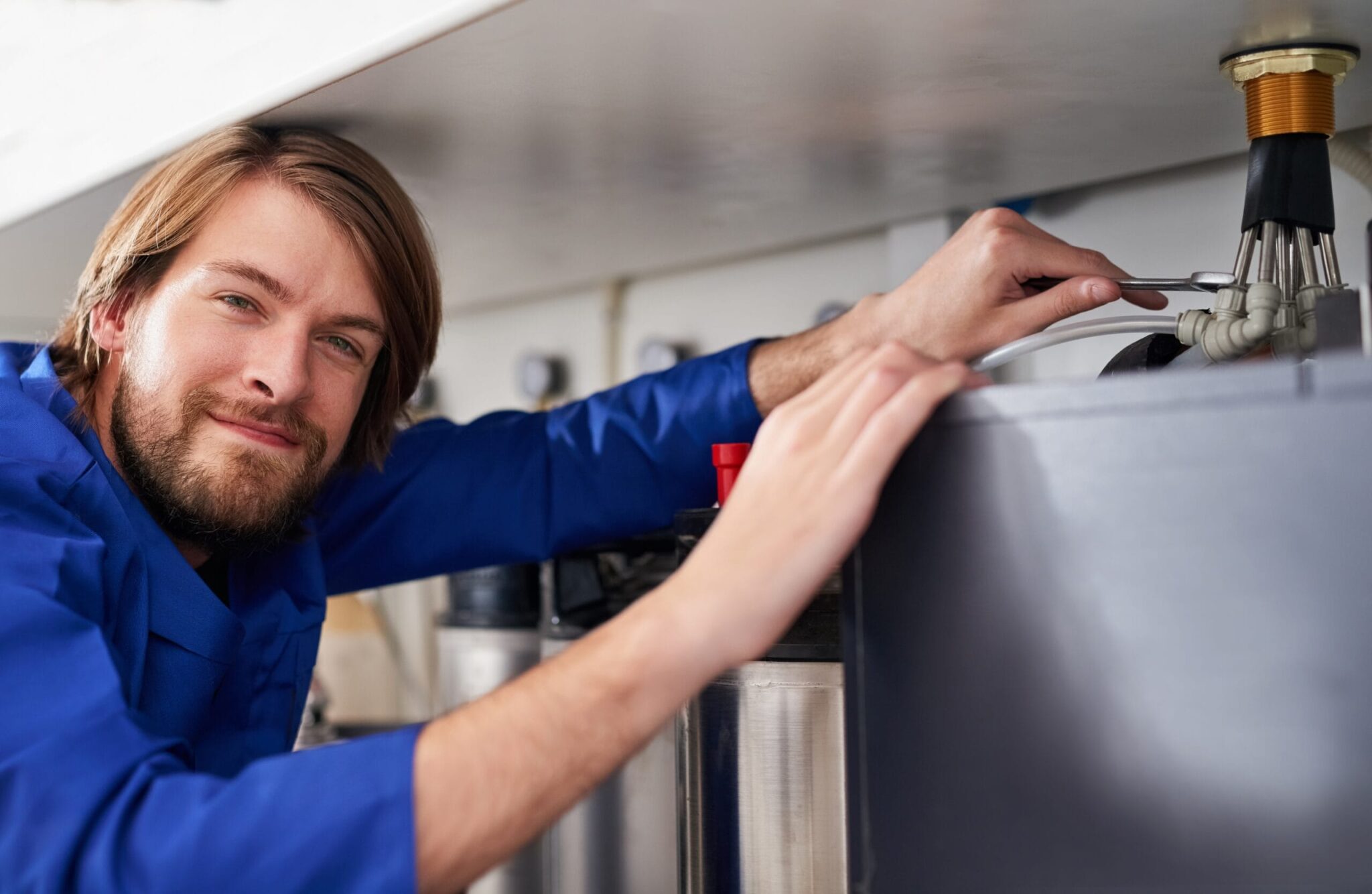 Technician servicing a residential water heater tank in Largo
